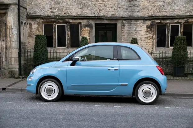 A light blue Fiat 500, seen from the side