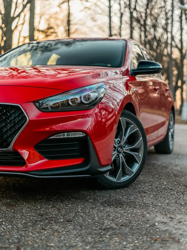 A red Hyundai hatchback, seen from the front