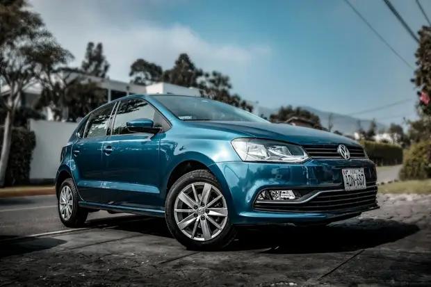 A turquoise Volkswagen hatchback, seen from the front